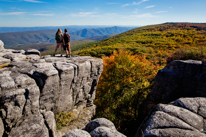 Image shows a couple looking off the edge of a cliff in West Virginia.